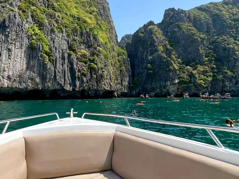 View from the bow of a private speedboat towards limestone cliffs