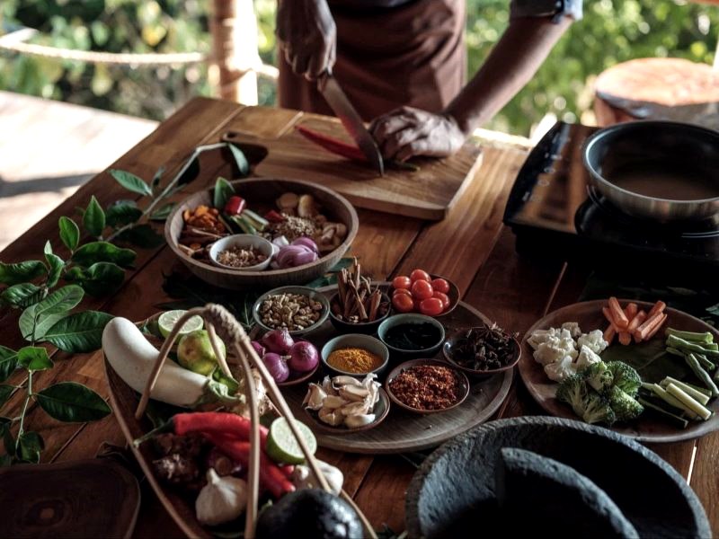 Thai cooking class table with fresh herbs, spices and vegetables